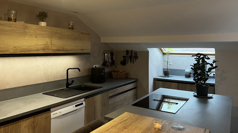 Cuisine moderne avec armoires en bois et robinet noir chez Vaxelaire Rémi.